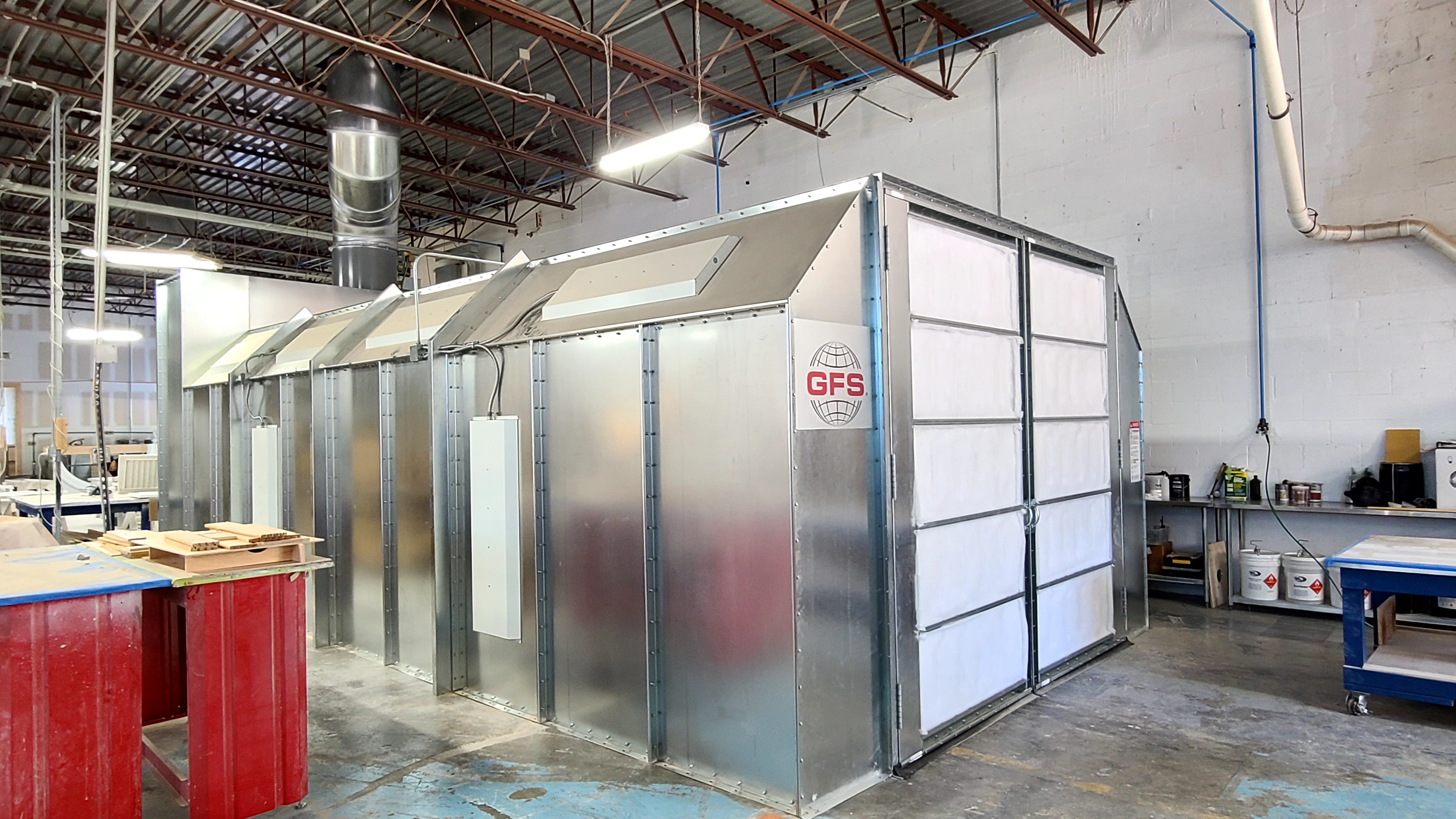 Industrial spray booth and overhead exhaust ductwork in finishing shop